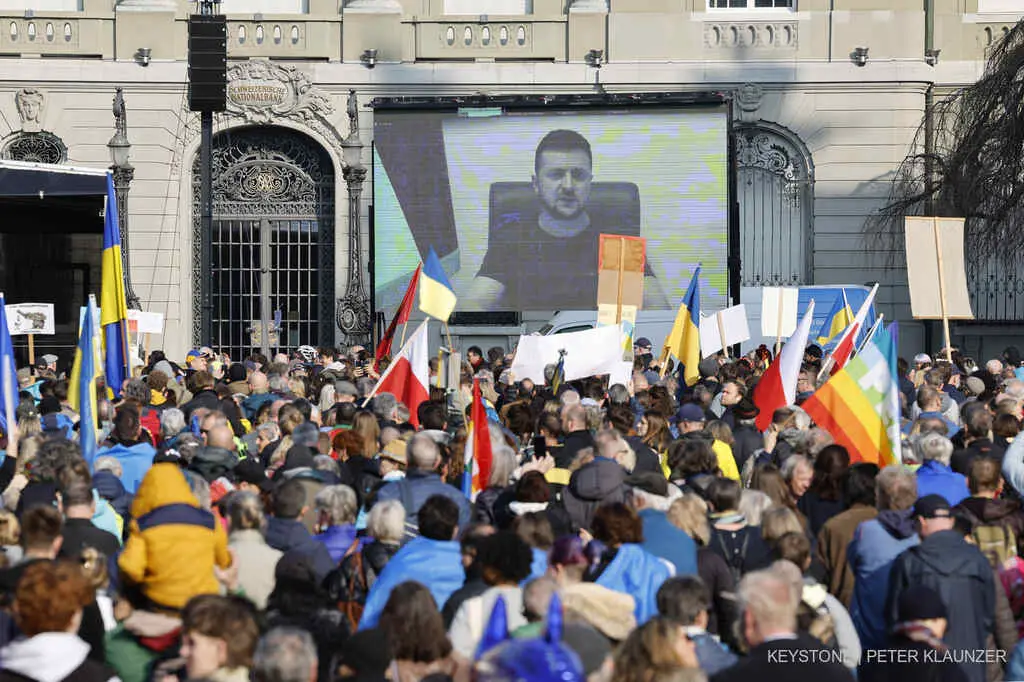 Ukrainian President Volodymyr Zelensky is displayed on a screen during a demonstration against the Russian invasion of Ukraine in front of the Swiss parliament building in Bern, Switzerland, Saturday, March 19, 2022