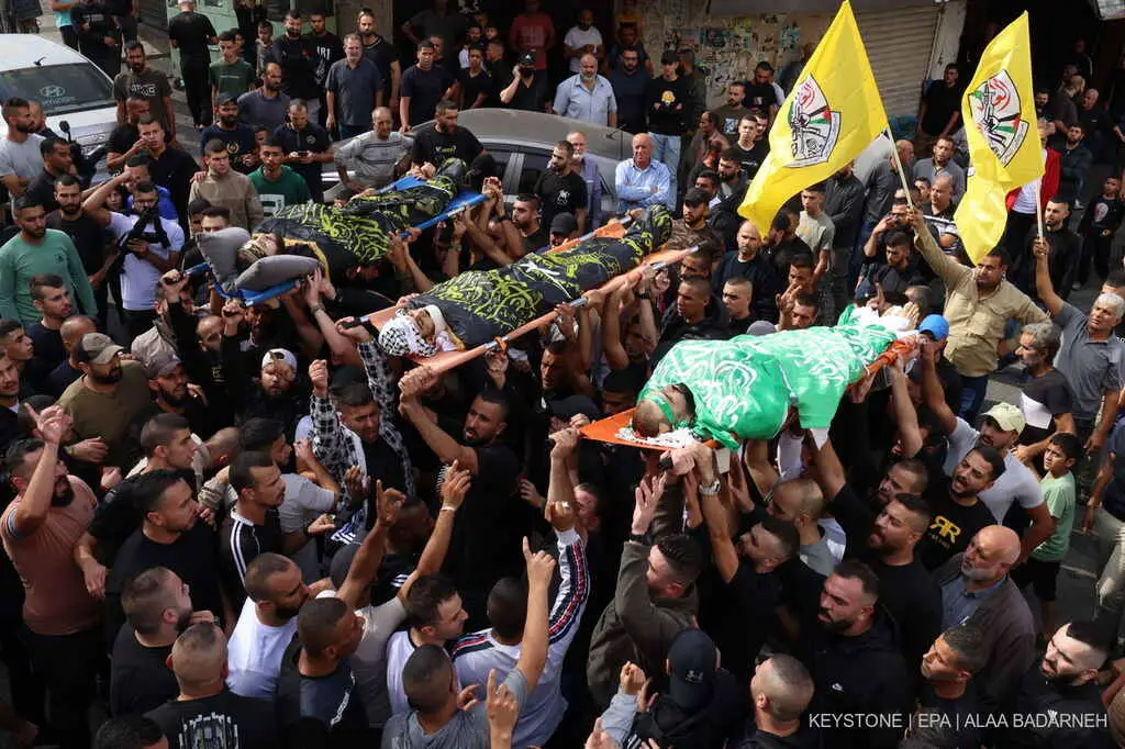 Mourners carry the remains of three men killed after an Israeli raid on Jenin refugee camp in the West Bank city of Jenin , 17 November 2023